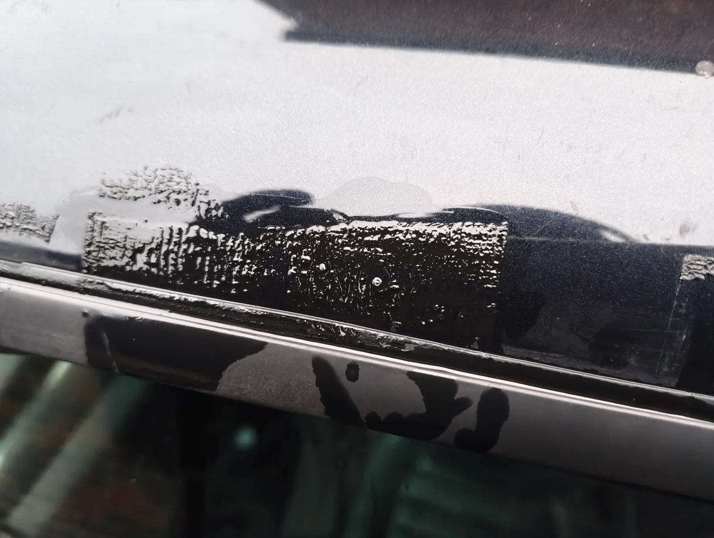 Car paint with adhesive on