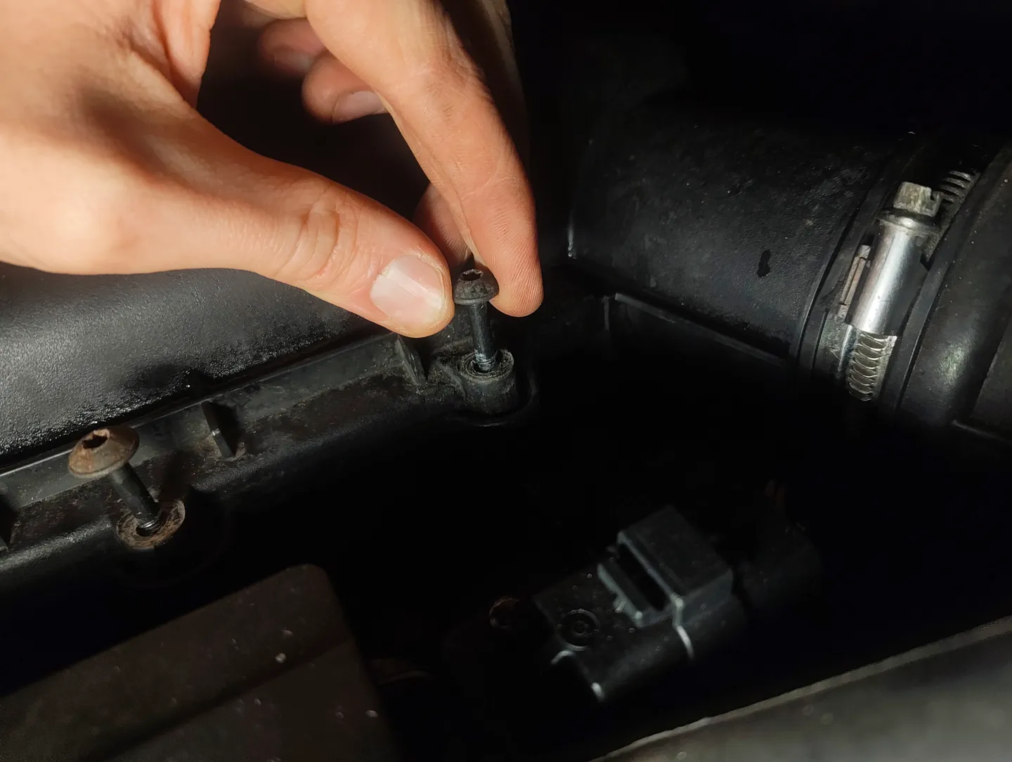 Holding up air filter housing cover screw