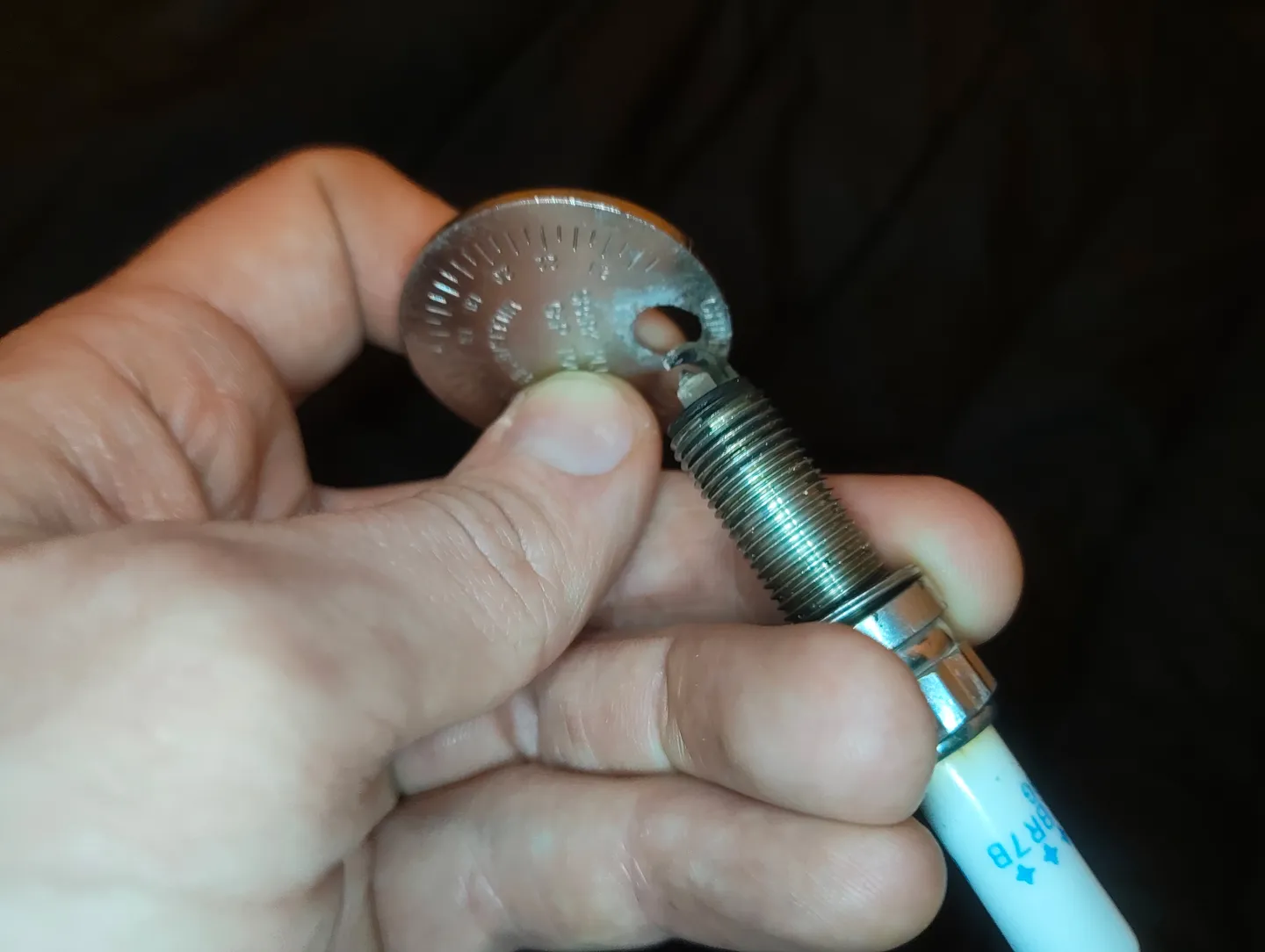 Inserting spark plug into gauge tool