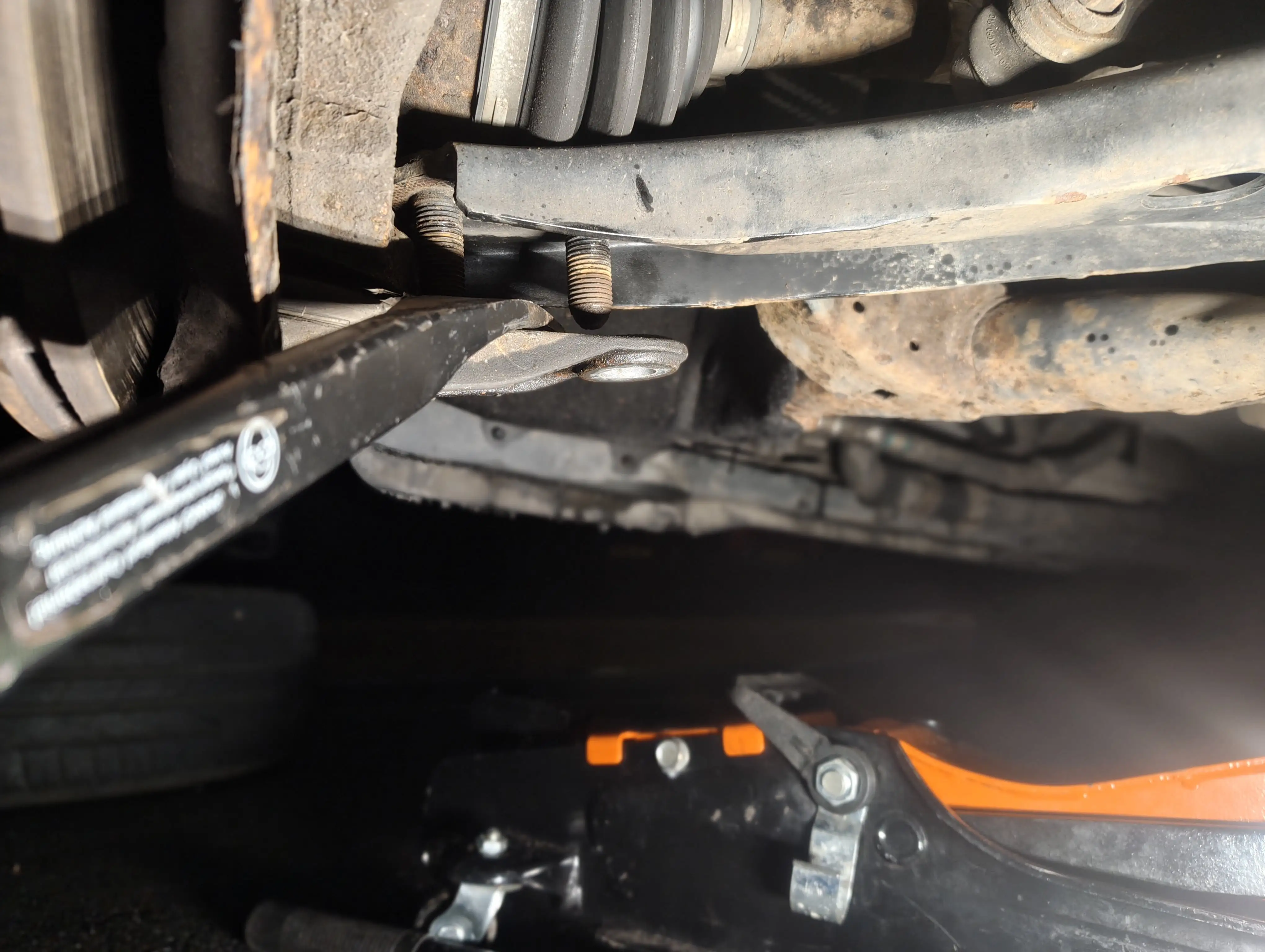 Prying the front passenger-side lower ball joint bracket from the lower suspension arm