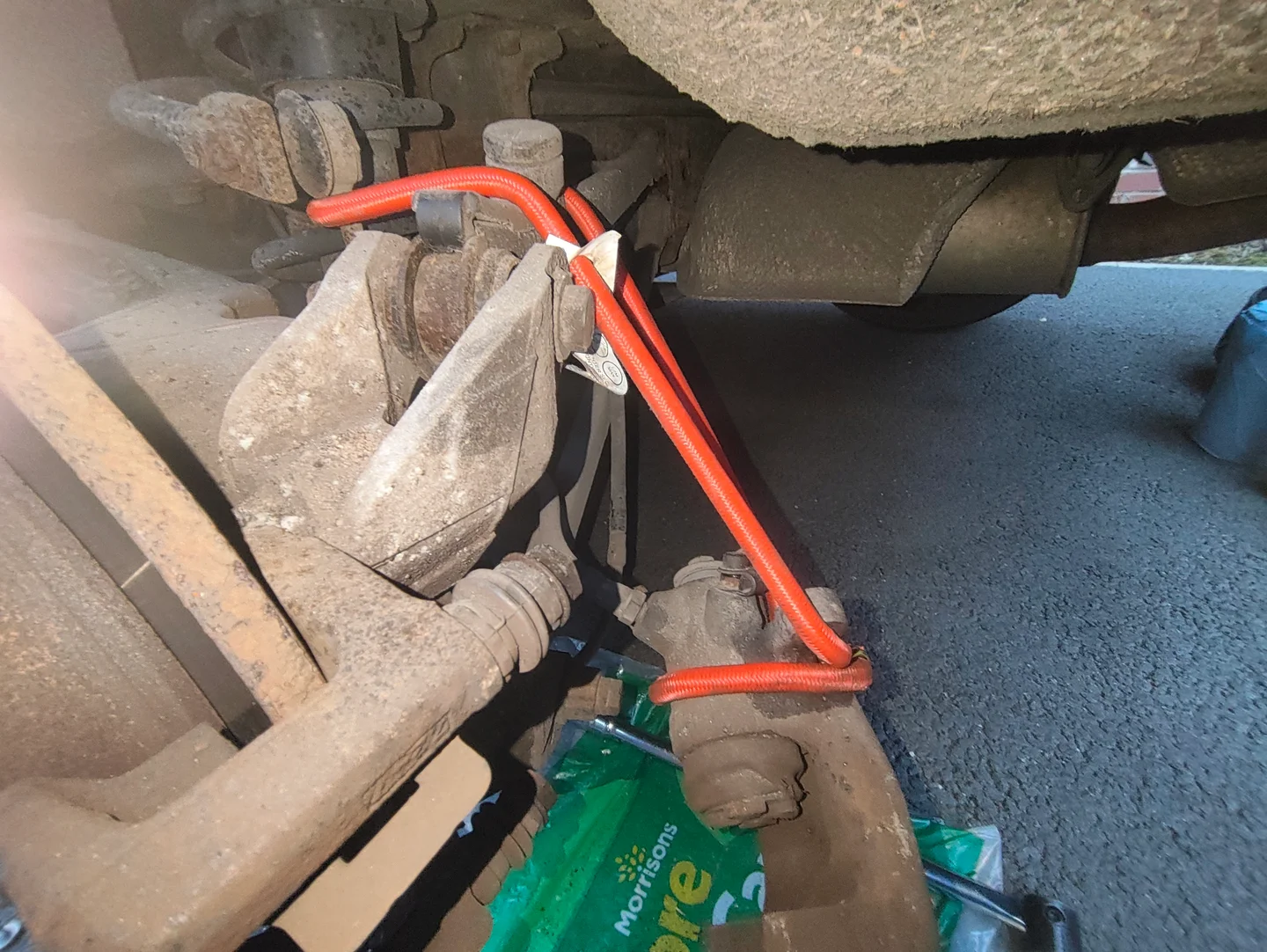 Rear brake caliper suspended by bungee cord