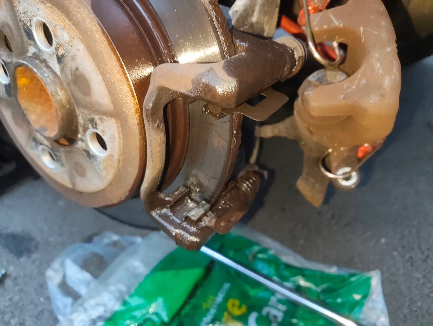Rear brake disc covered in brake cleaner