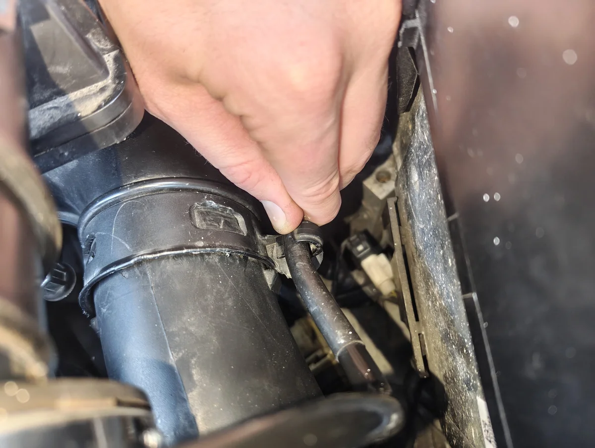 Unclipping vacuum line from air intake duct