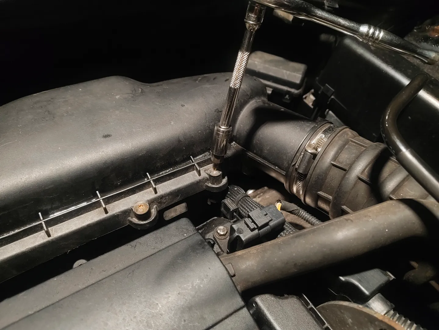 Unscrewing air filter housing screws