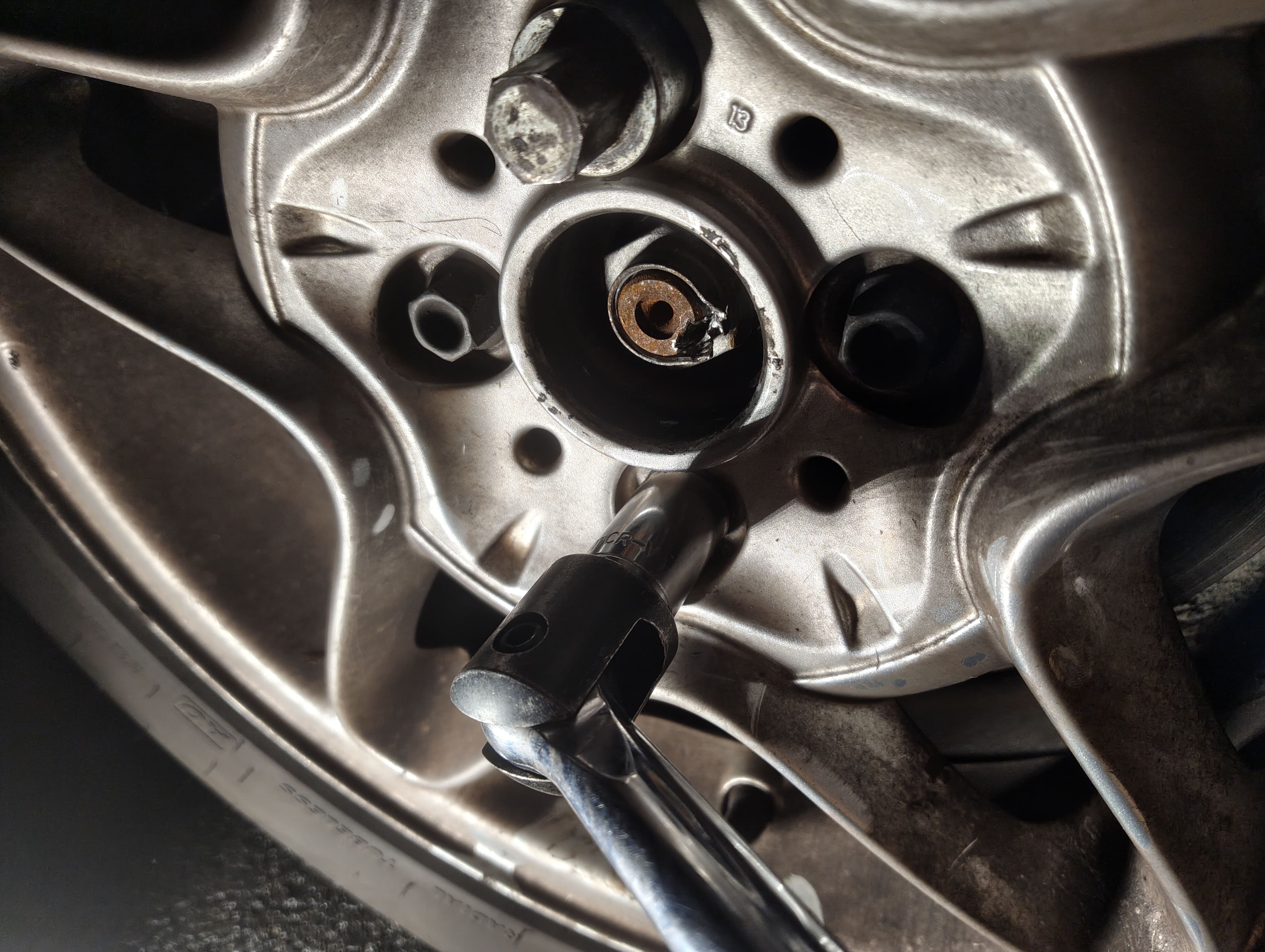 Loosening the front passenger-side lug nuts with a breaker bar