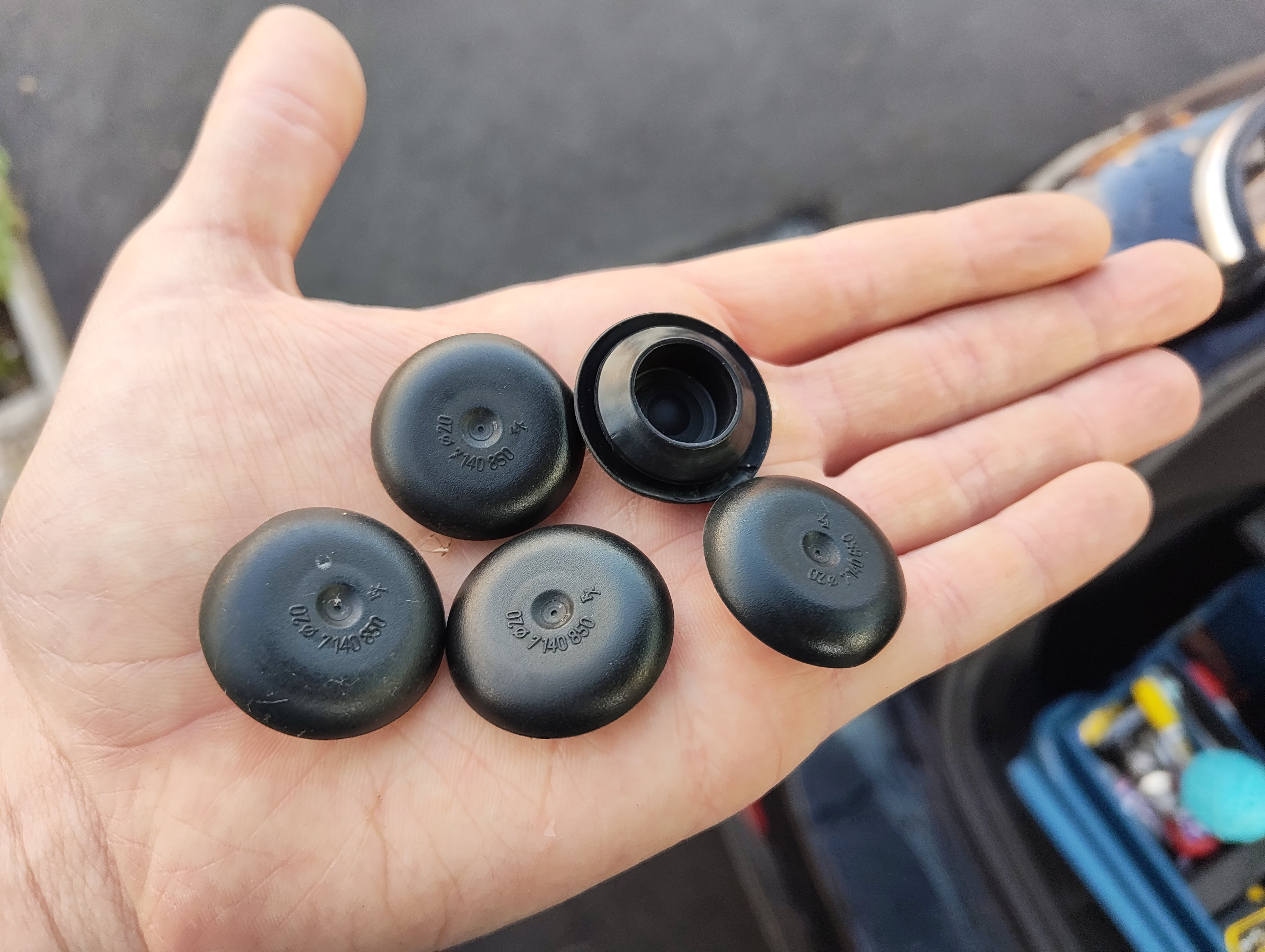 Five rubber caps held in a hand